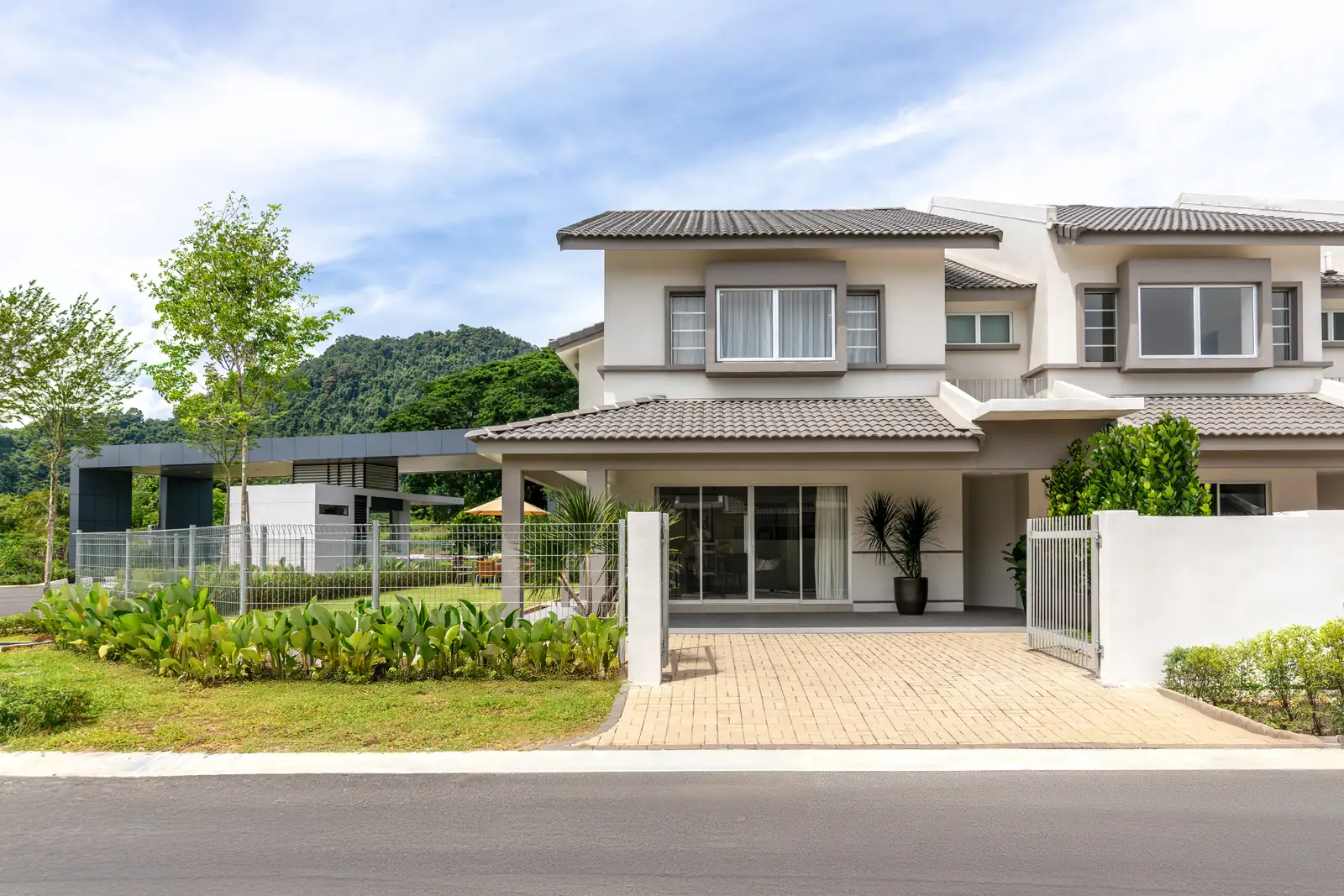 Olive Grove corner unit double-storey terrace facade with limestone hill backdrop, Bercham Ipoh